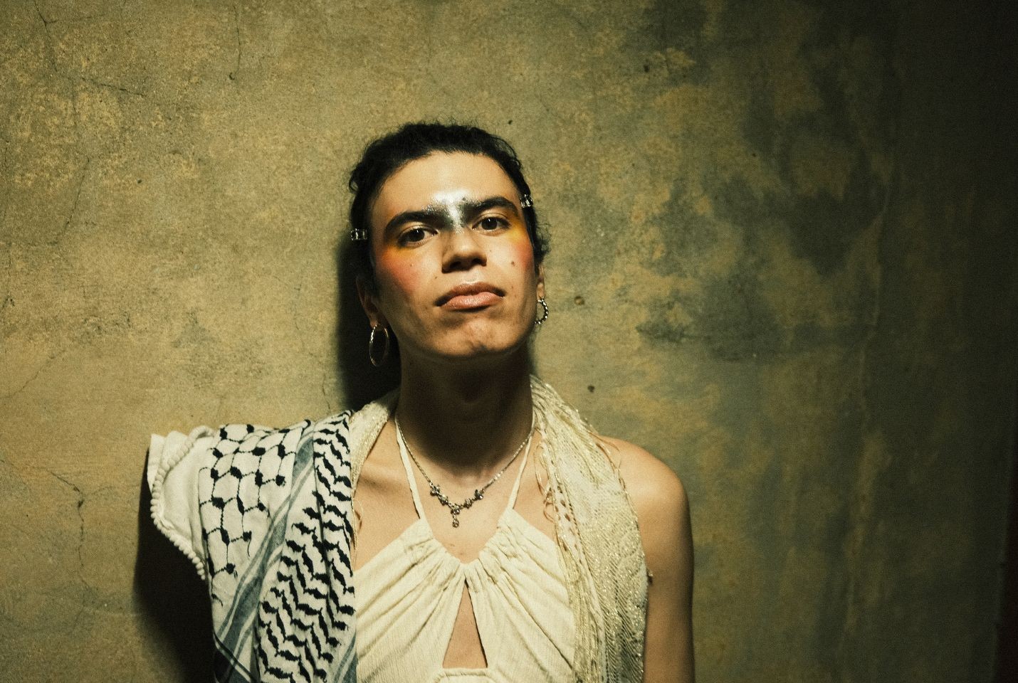 Jacob Alon wearing a white dress and keffiyah
